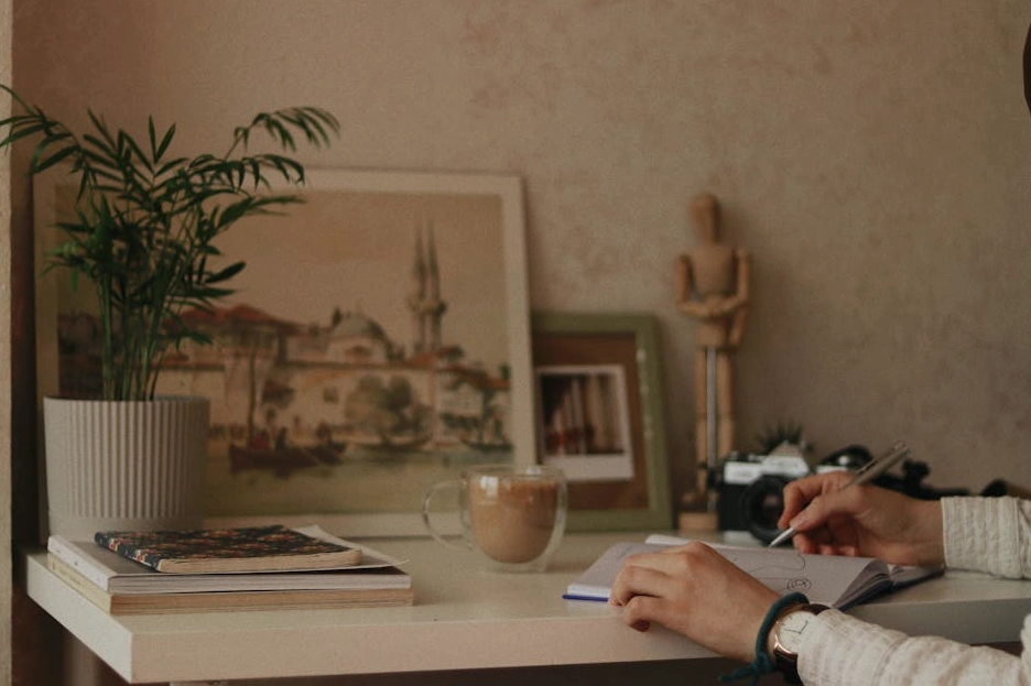 Persona che scrive su un taccuino in un ambiente di lavoro creativo