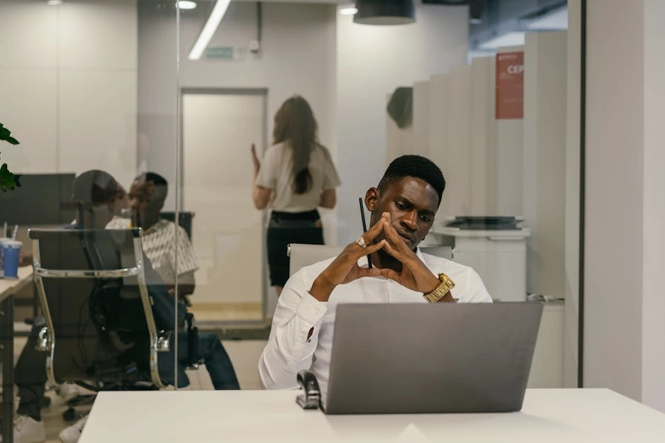 Professionista del marketing sorridente che lavora su un laptop in un ufficio moderno